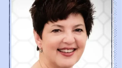 A headshot of a smiling woman with short hair.