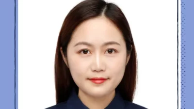 A headshot of a woman wearing red lipstick on a white background.