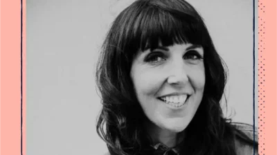 A black and white headshot of a smiling woman