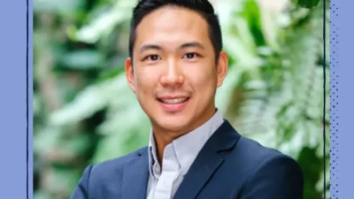 A headshot of a smiling man in a suit.