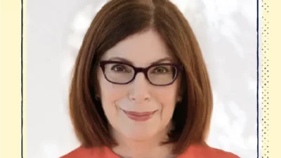 A headshot of a woman with short hair and dark glasses.