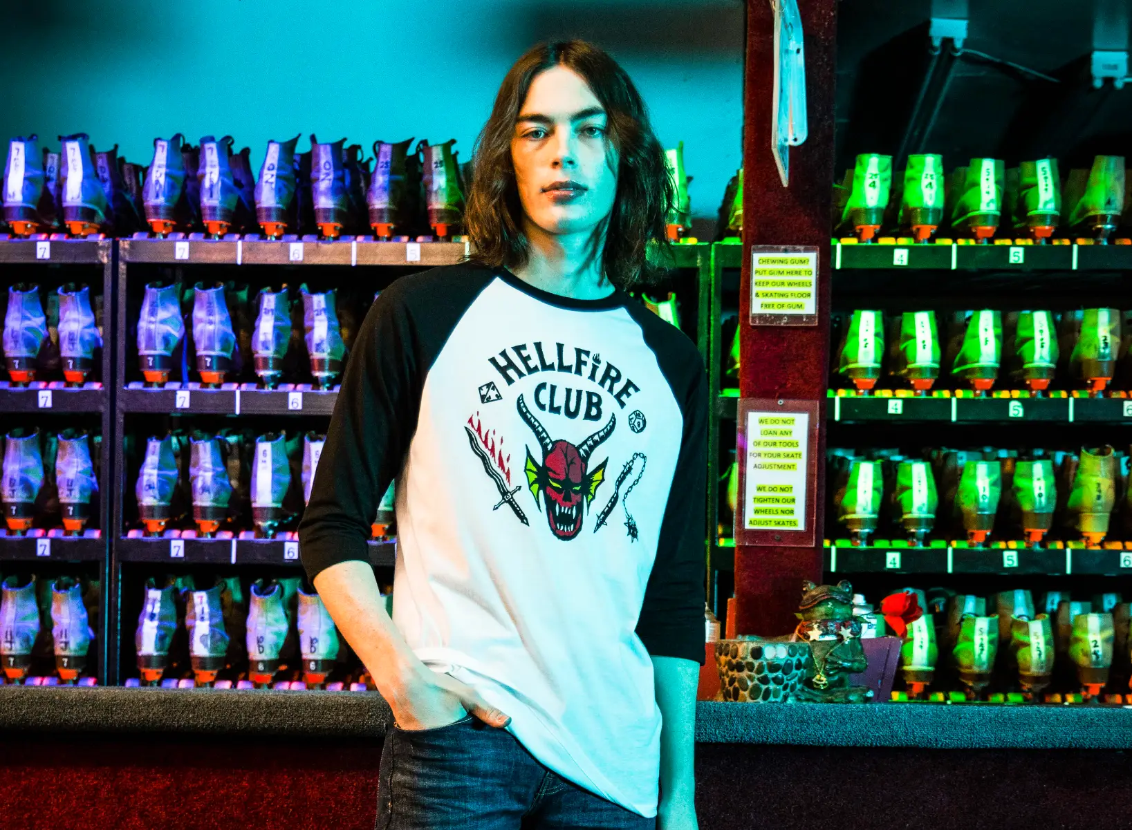 Person standing in a bowling alley with a Hellfire Club t-shirt on.