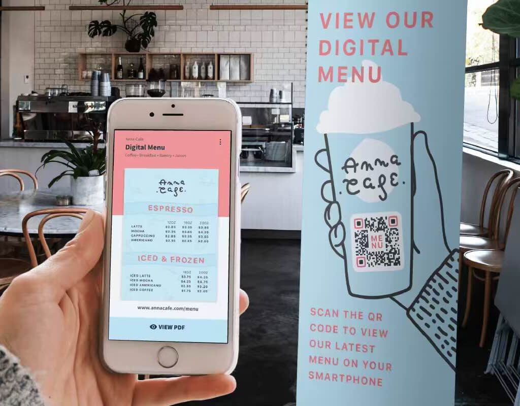 A person holding their smartphone with a cafe menu pulled up next to the cafe banner which has a QR Code for their menu on it